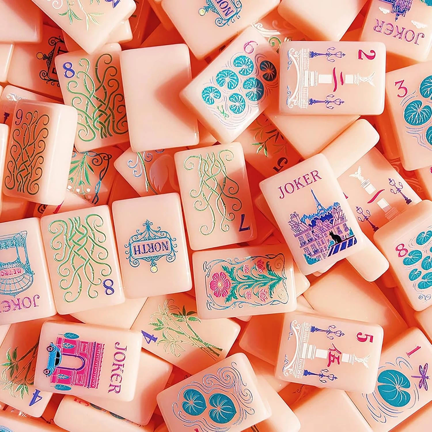 Pink Paris Mahjong acrylic tiles scattered on a table showing detailed patterns